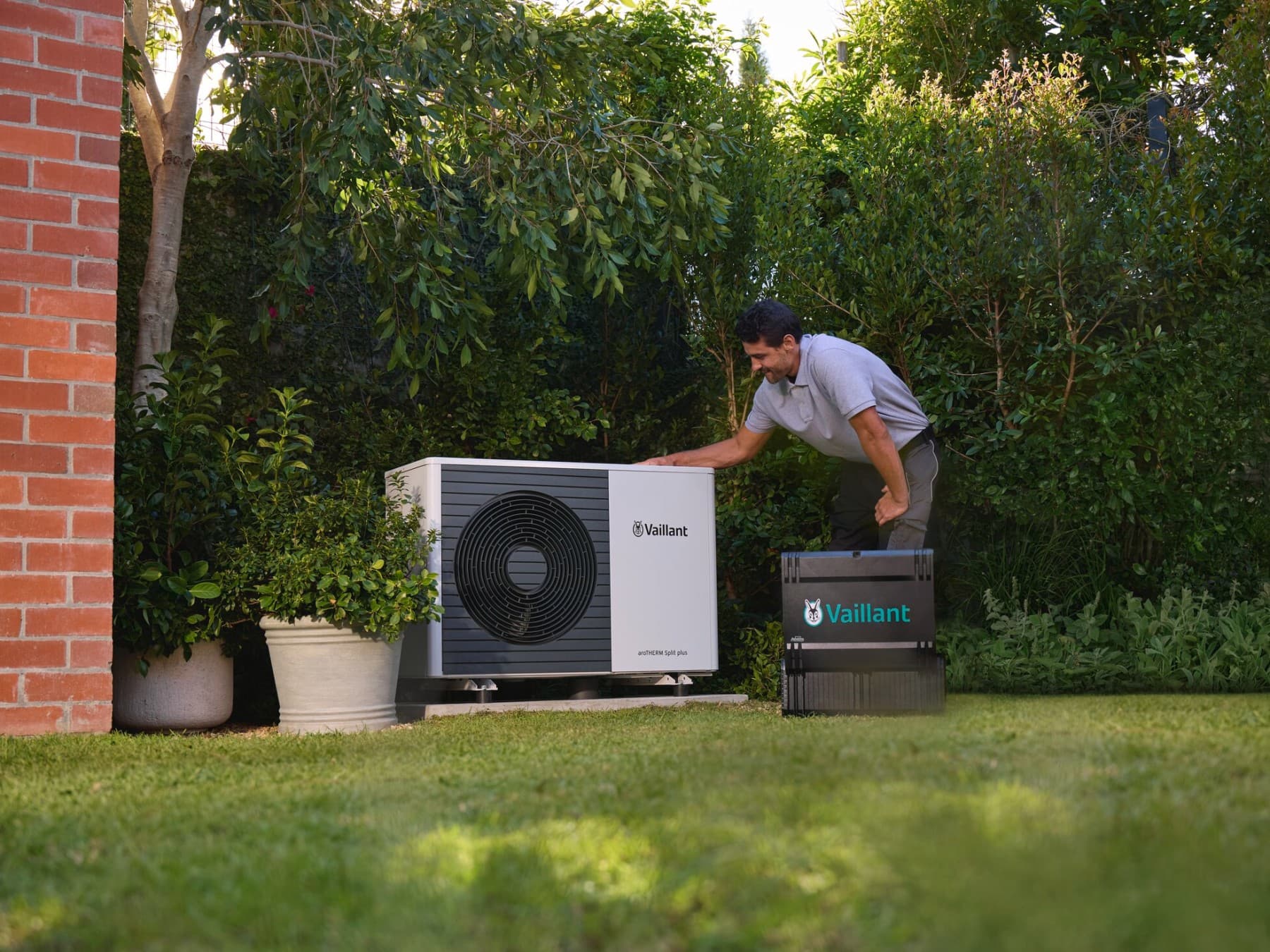 Installateur vérifiant une unité extérieure d'une pompe à chaleur dans un jardin