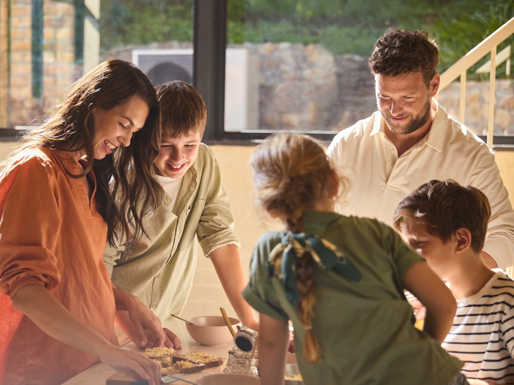 Une famille coupant un gâteau dans leur cuisine | Vaillant
