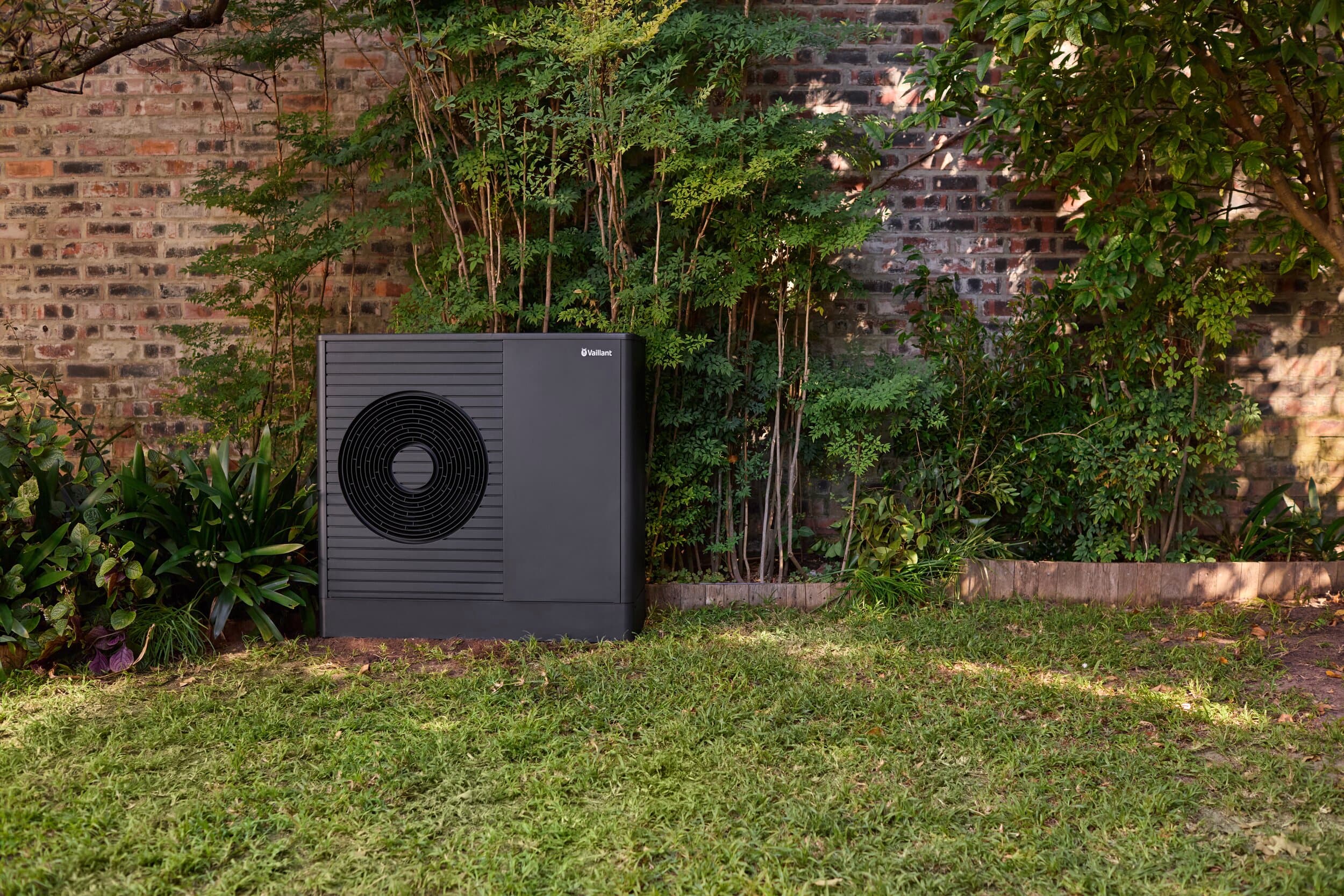 Une unité extérieure d'une aroTHERM Pro dans un jardin | Vaillant