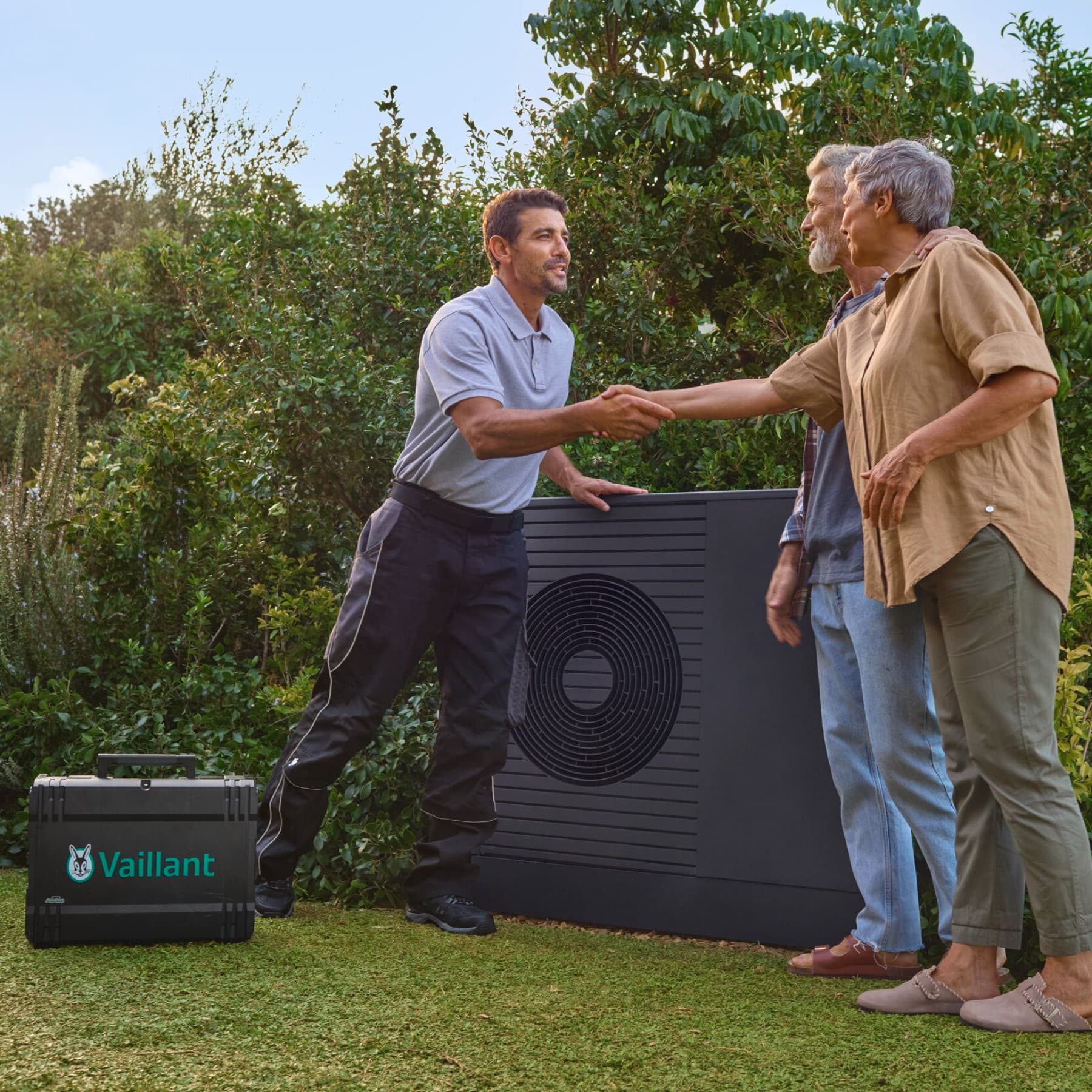 Un installateur serre la main d'un client dans un jardin | Vaillant