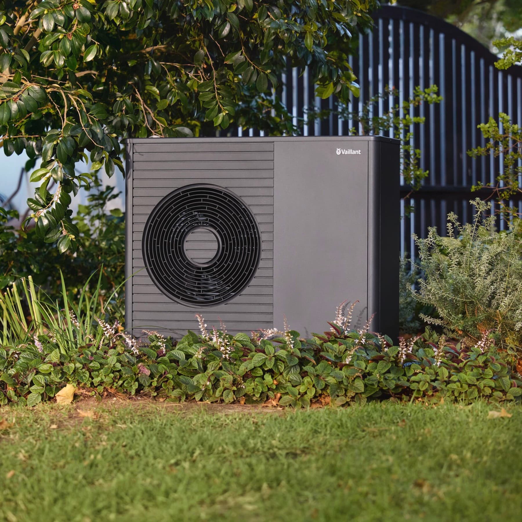 Une unité extérieure de PAC dans un jardin | Vaillant