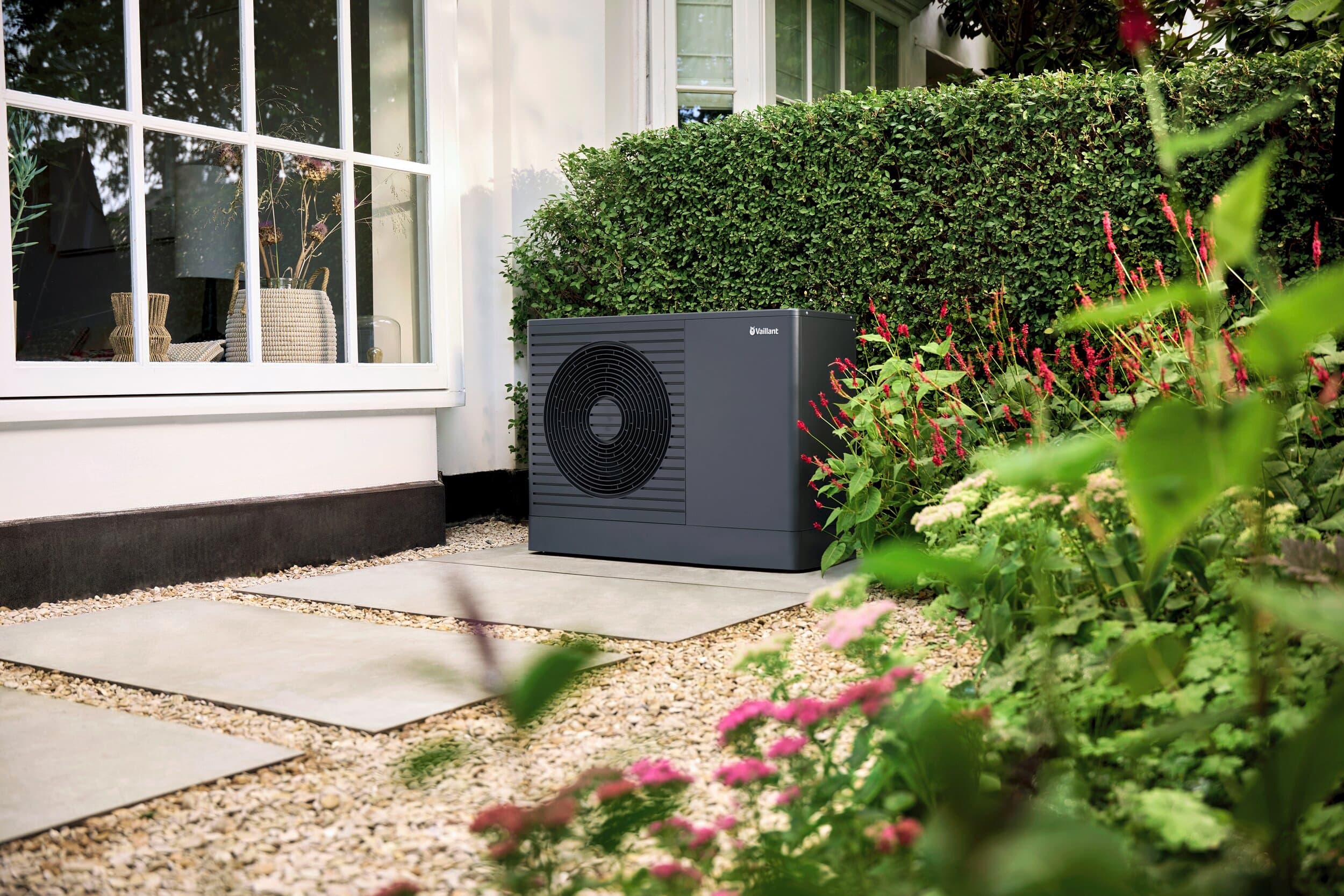 Une unité extérieure d'une aroTHERM Pro dans un jardin | Vaillant