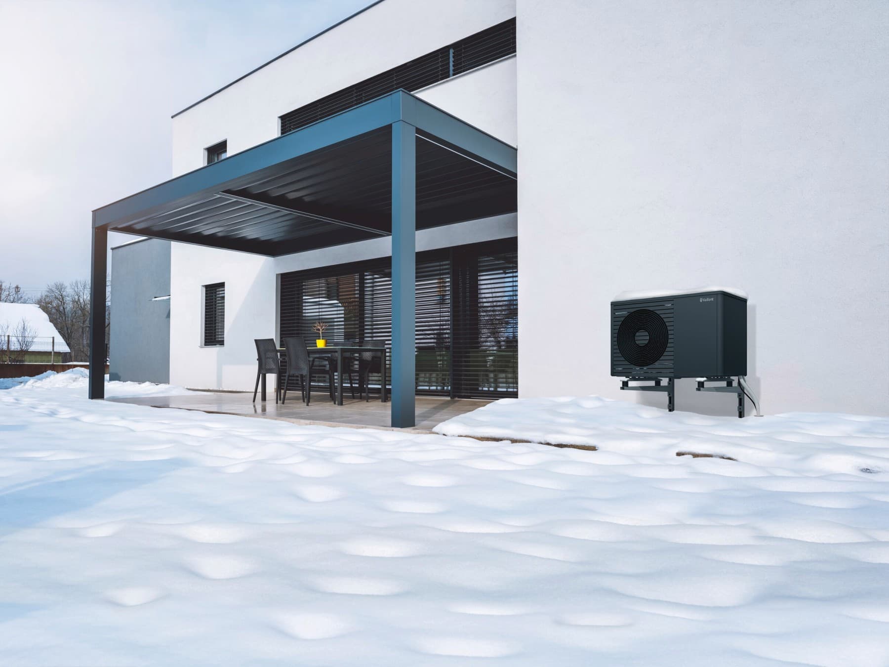 Jardin d'hiver avec pompe à chaleur recouverte de neige | Vaillant