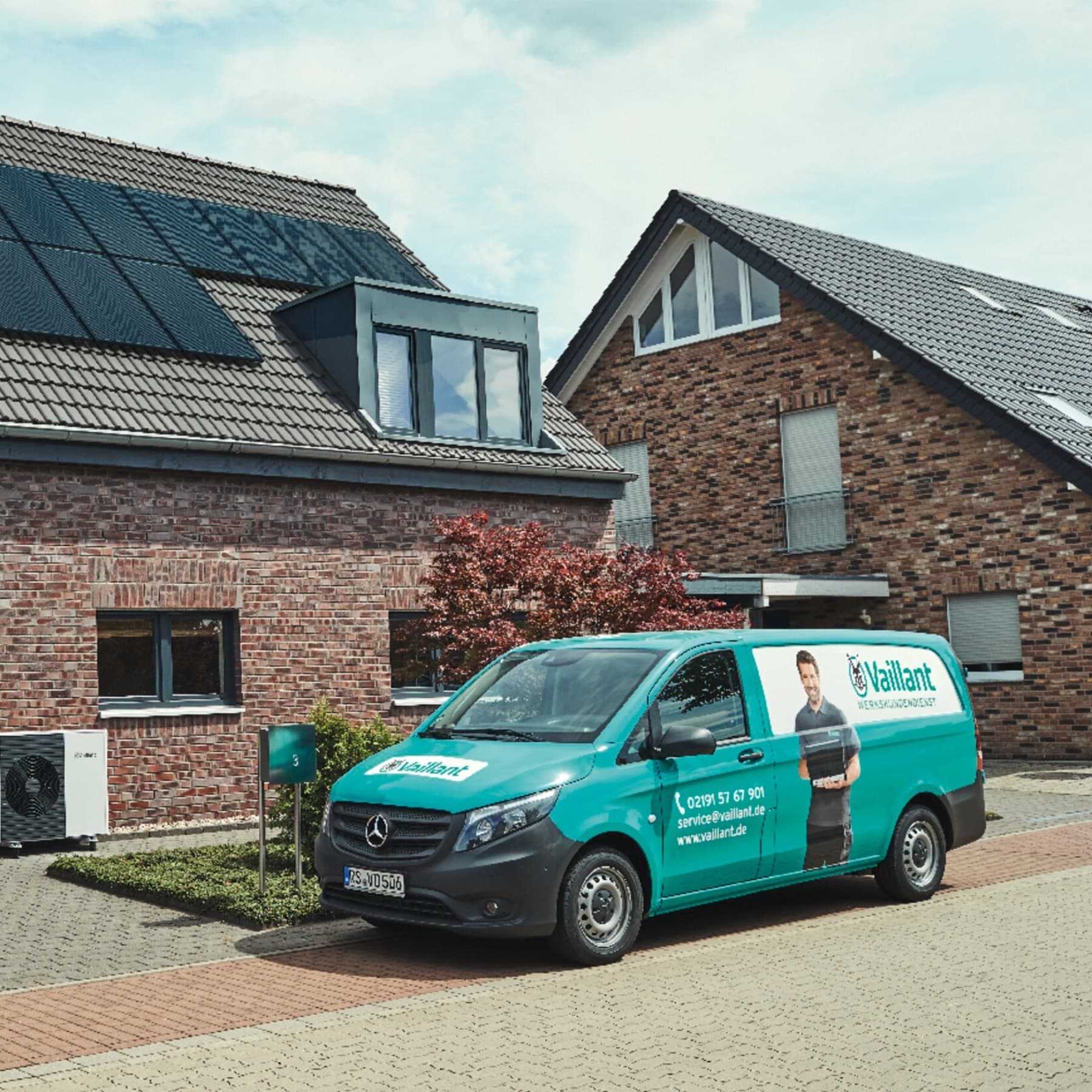 Un utilitaire garé devant une maison sur laquelle des panneaux solaires sont posés sur le toit | Vaillant