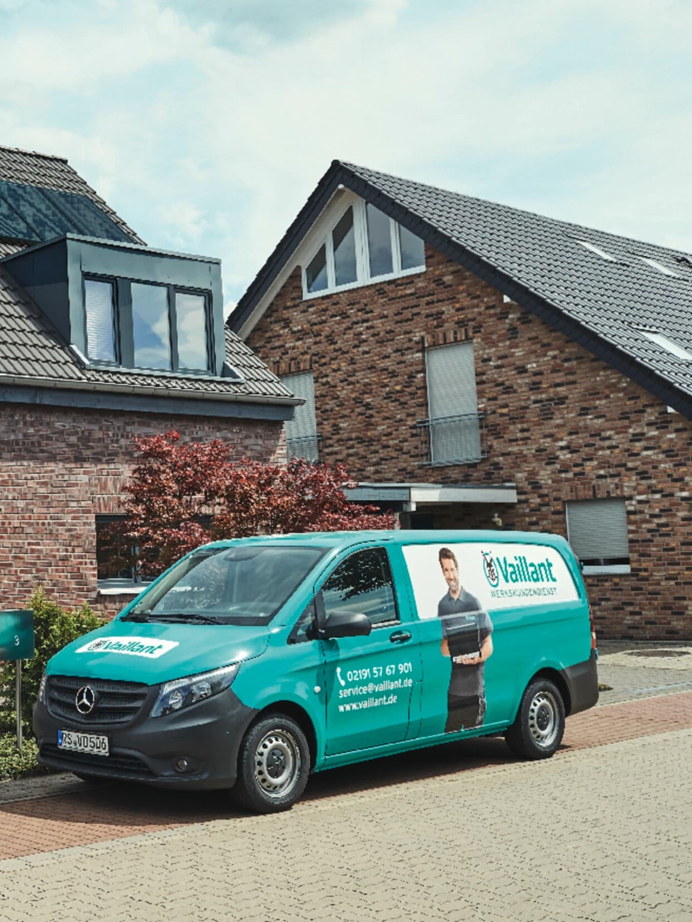 Un utilitaire garé devant une maison sur laquelle des panneaux solaires sont posés sur le toit | Vaillant