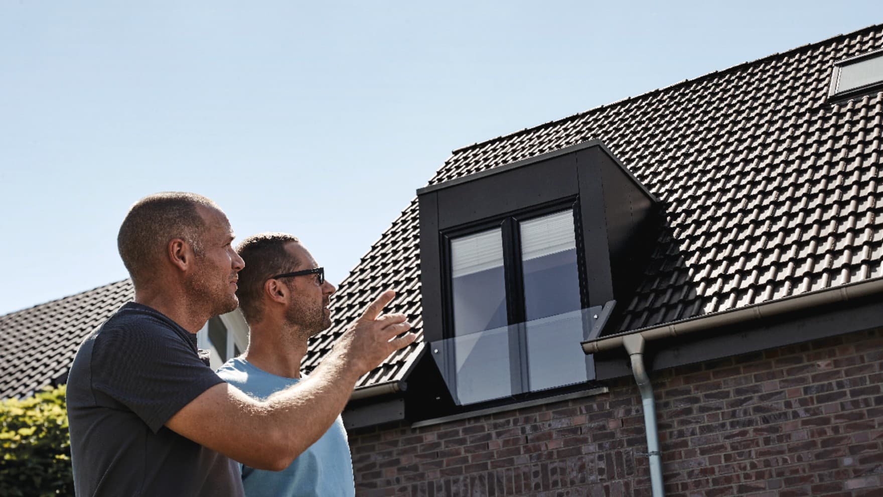 Les artisans et le propriétaire inspectent le toit rénové | Vaillant