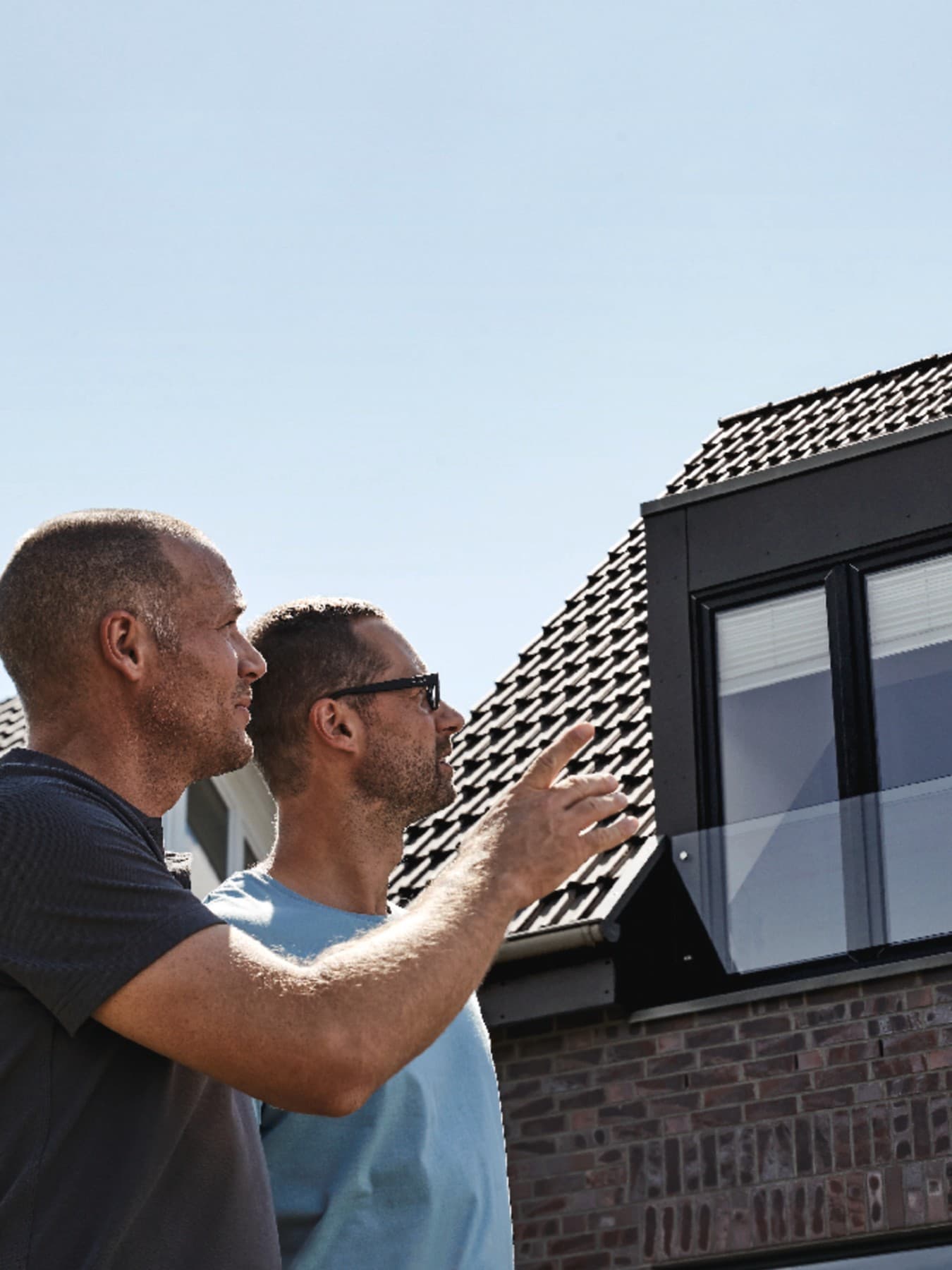 Les artisans et le propriétaire inspectent le toit rénové | Vaillant