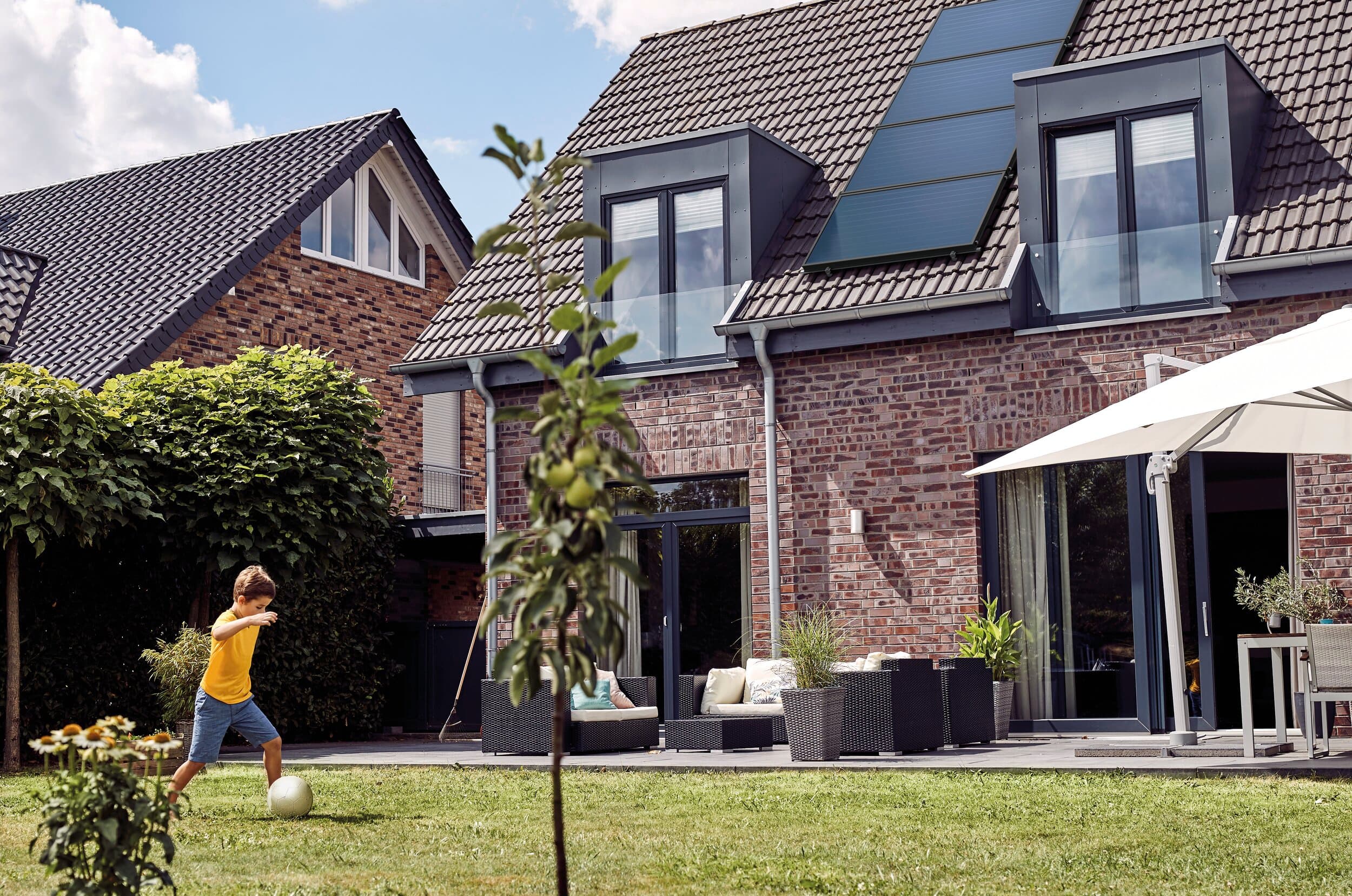 Un enfant en train de jouer au ballon dans un jardin | Vaillant