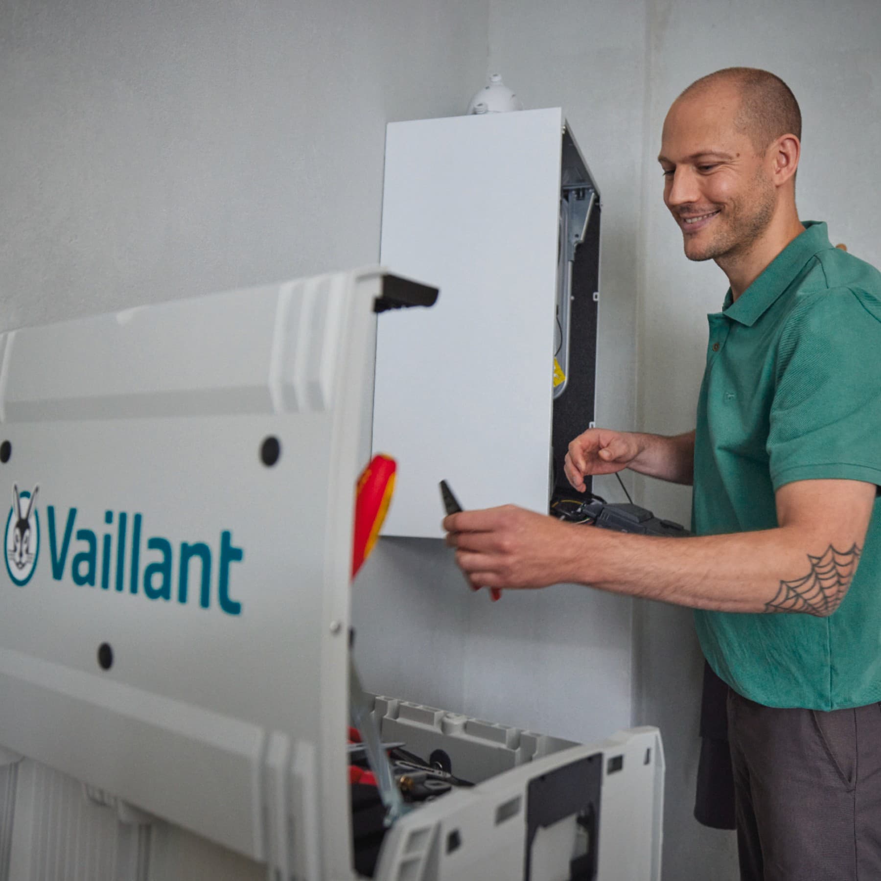 Un SAV Vaillant est en train de dépanner un chauffe-eau gaz dans une buanderie | Vaillant
