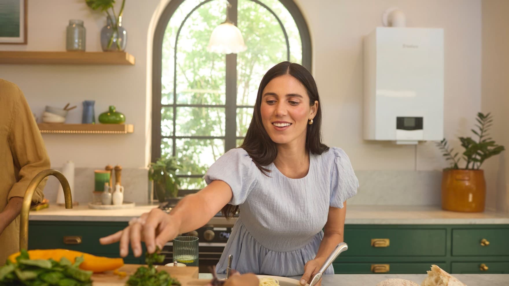 Femme dans une cuisine devant une chaudière | Vaillant