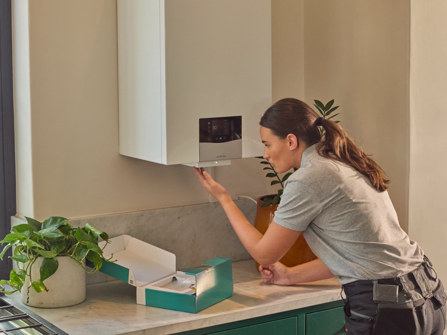 Installateur raccordant une nouvelle chaudière à condensation au gaz | Vaillant