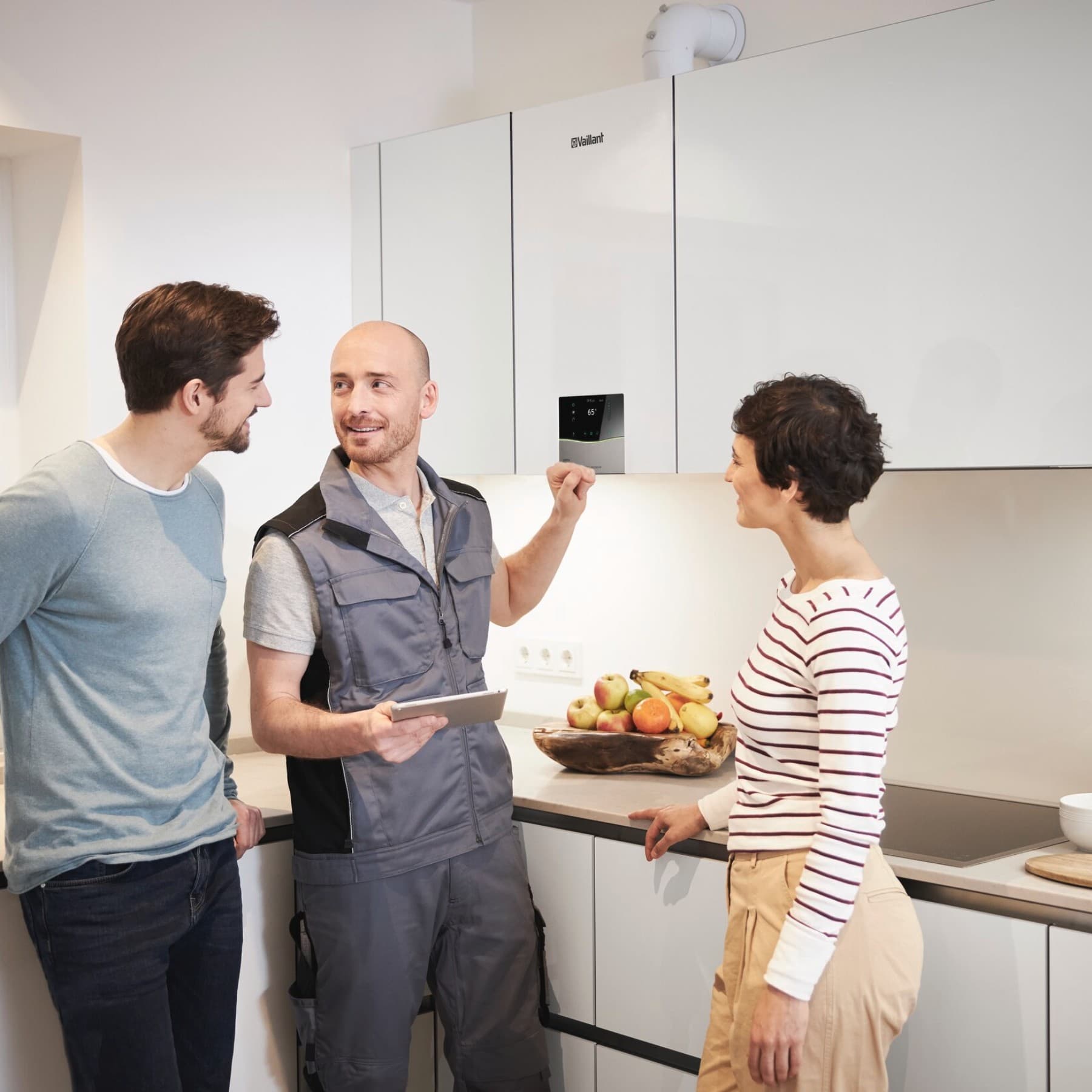 Conseil sur les chaudières à domicile - couple en discussion avec un installateur | Vaillant