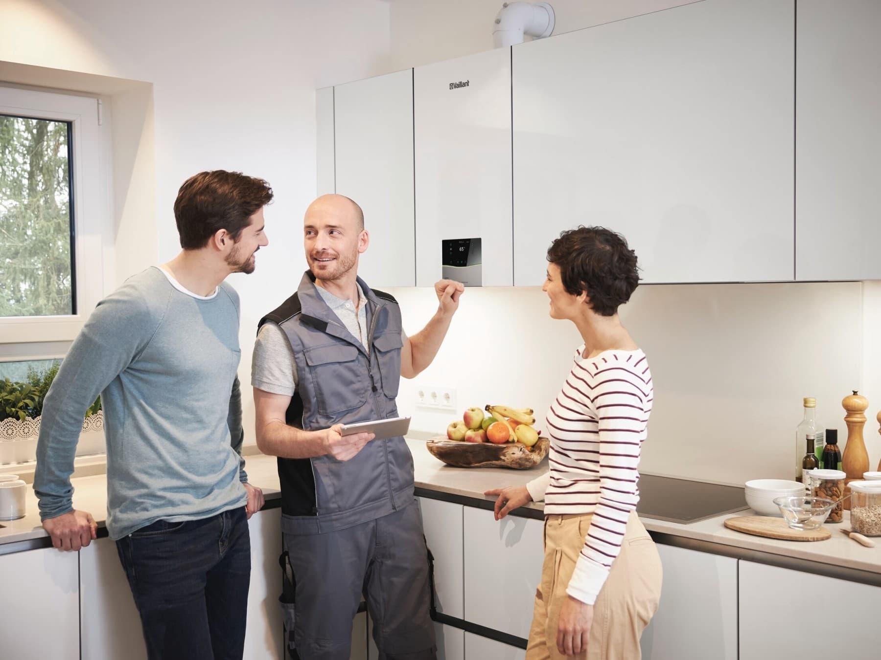 Conseil sur les chaudières à domicile - couple en discussion avec un installateur | Vaillant